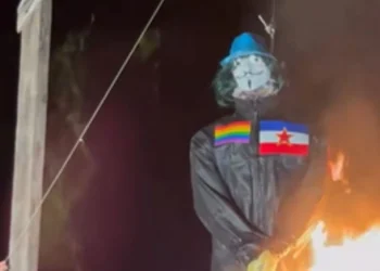 Lutka u crnom kombinezonu s maskom Guyja Fawkesa, duginom zastavom i zastavom Jugoslavije na prsima tijekom spaljivanja u Novigradu